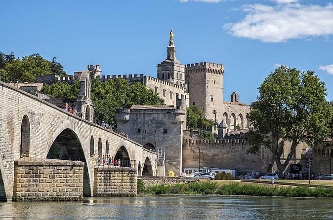 Arches of the old bridge in the foreground and the towers of the popes' palace above the walls