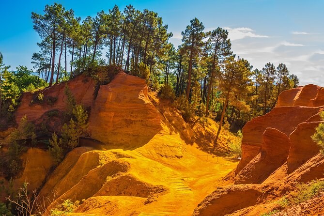 Orange and yellow ochre cliffs and pines on the trail at Roussillon