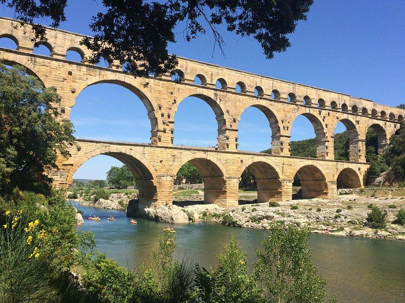 The three tiers of the Roman aqueduct bridge over the green Gardon river